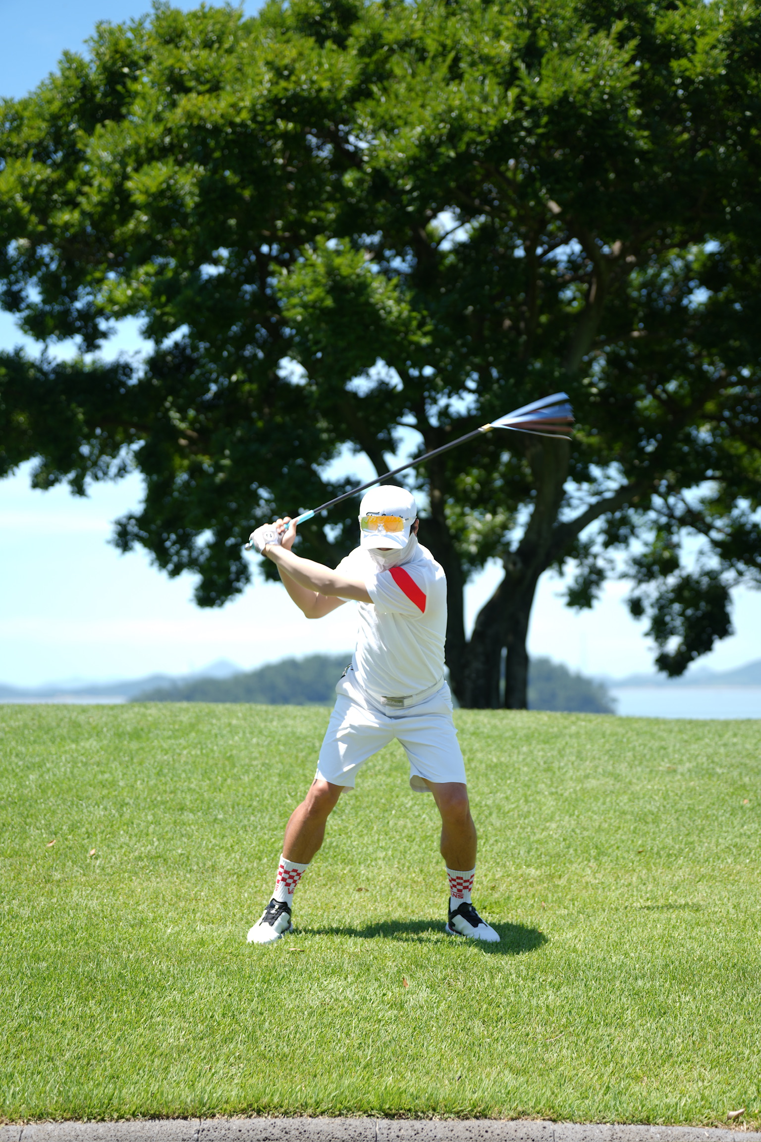 Swing trainer mode — golfer mid-swing with swing strap